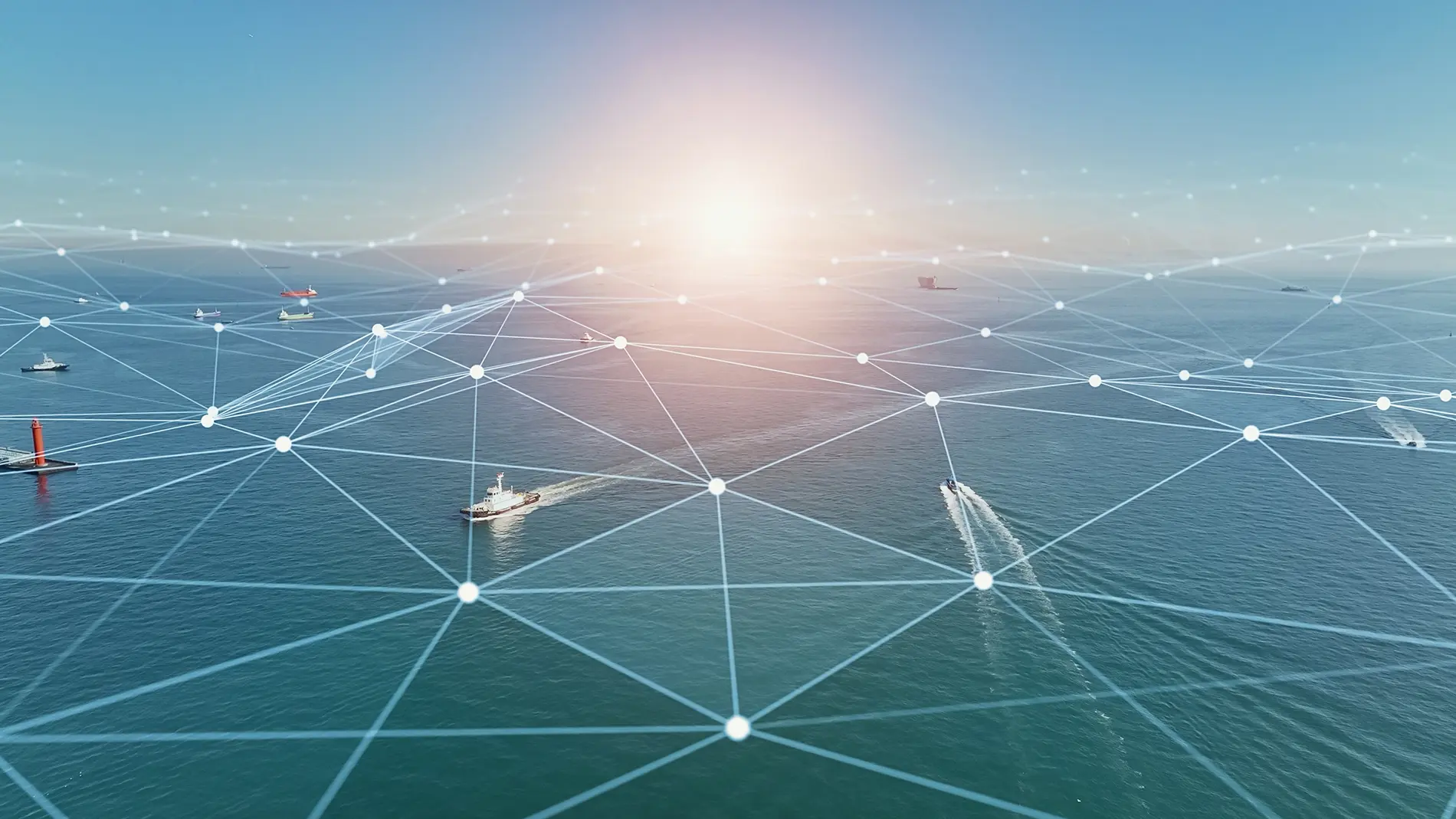 A digital network overlay with interconnected lines and dots covers an ocean scene with boats from the Patagonian toothfish fishery, under a clear sky and setting sun, symbolizing maritime connectivity or communication.