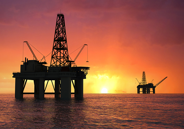 offshore oil rig with sunset in background