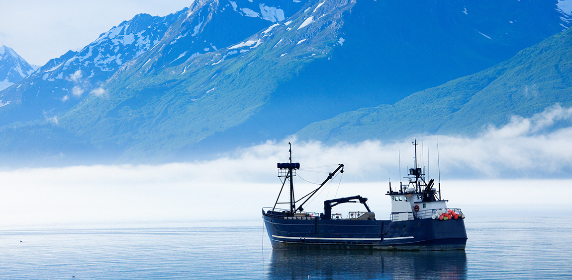 fishing boat with mountain behind